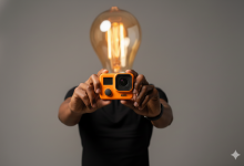 Phil A. Ment hold up an orange action camera.